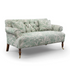 Bennett Sofa upholstered in green patterned fabric with a button-tufted back and brass castors