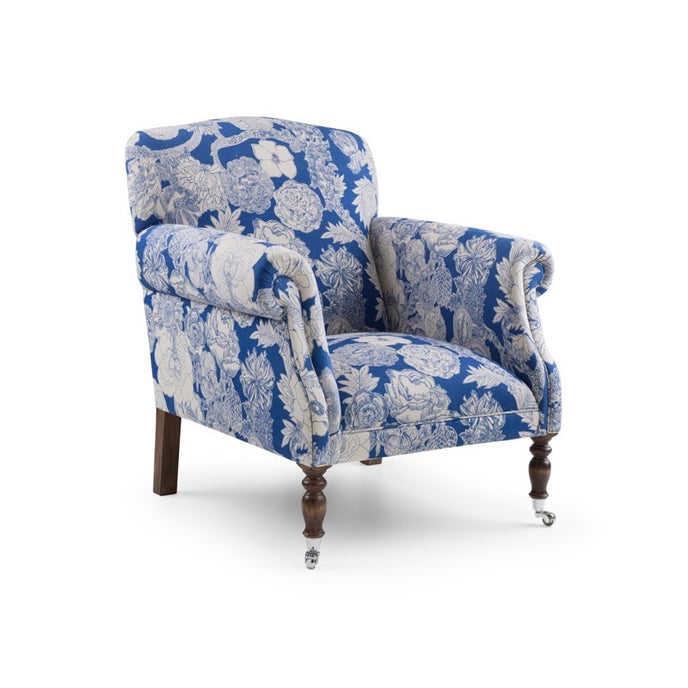 Liberty Chair upholstered in blue and white floral fabric with scrolled arms and turned wooden legs with chrome castors