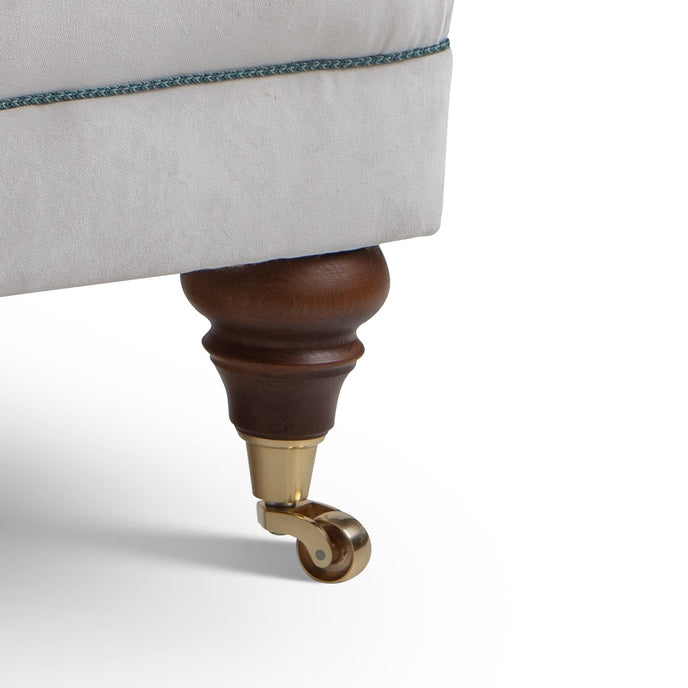 Close-up of a Library chair's leg with a wooden and brass finish 