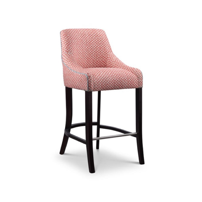 Soho Bar Stool upholstered in pink geometric fabric with dark wooden legs and a metal footrest