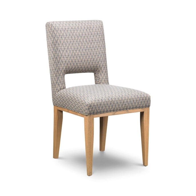 Spencer Dining Chair upholstered in grey fabric with a cut-out back detail and tapered wooden legs
