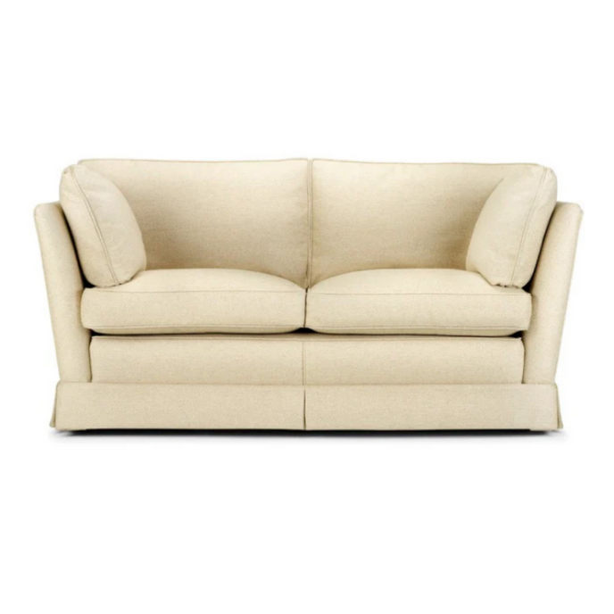 Oxford Sofa Bed upholstered in cream fabric with side cushions and a skirted base
